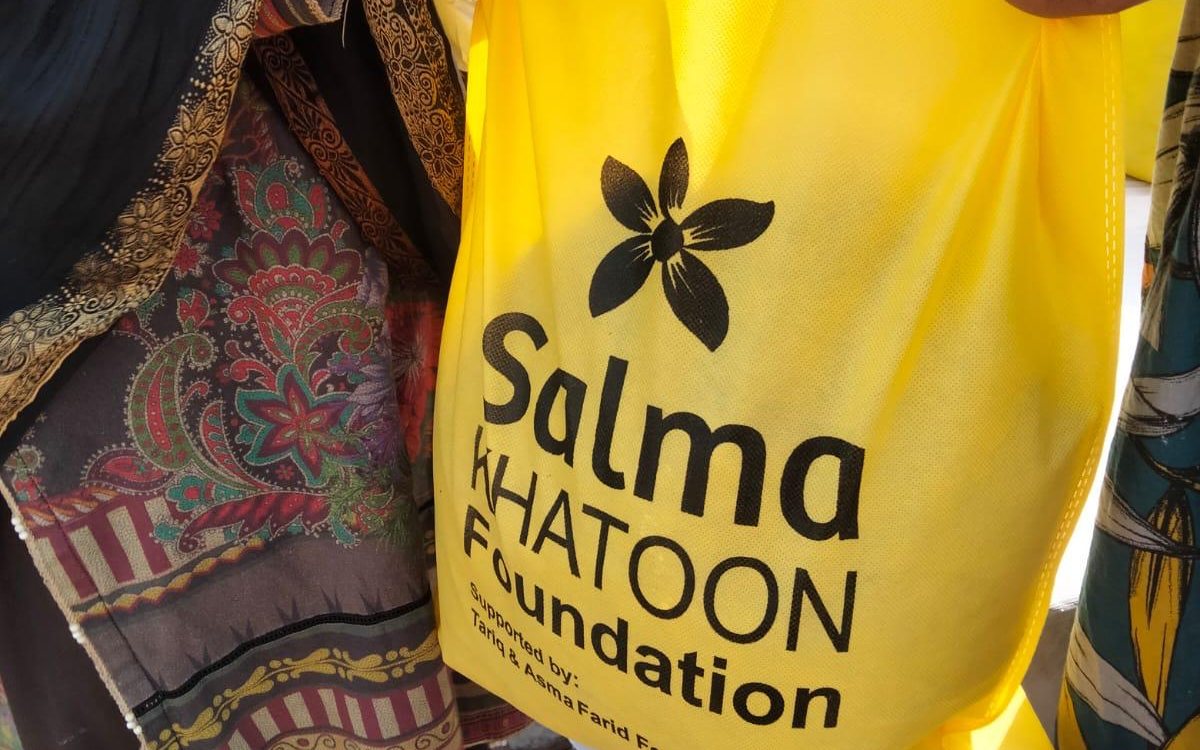 A Salma Khatoon Foundation ration bag, supported by the Tariq & Asma Farid Foundation, handed to a woman in Sahiwal