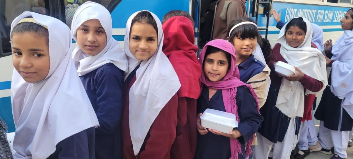 Schoolgirls in Sahiwal holding lunch boxes from the Salma Khatoon Foundation school lunch program